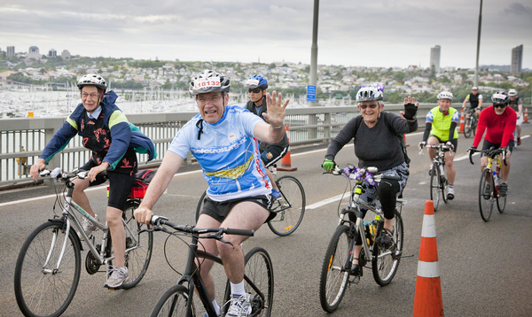 Auckland Mayor Len Brown riding over the crest of the Auckland Harbour Bridge.