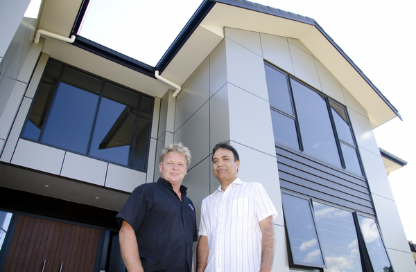 Shane Fowler (left) and Darshan Singh (right) with his home immediately behind.