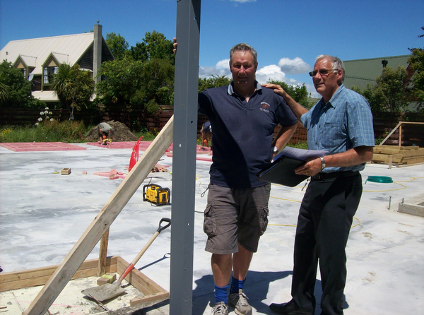 Phil Round (left) and Roy Price (right) with the background of work beginning on the Price home.