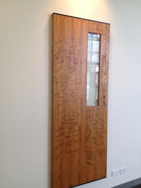 One of the doors signed by the students adorning the wall in Mana Wahine