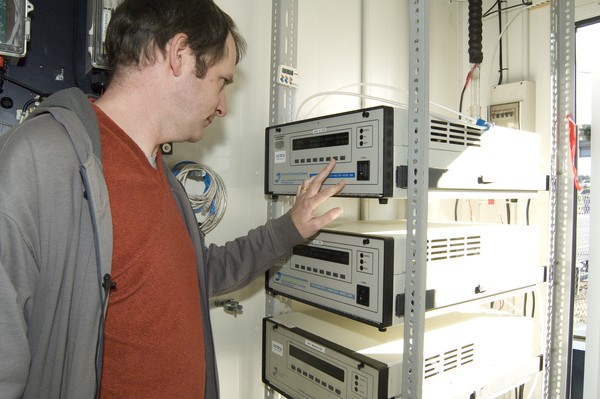 Dr Ian Longley inside an air quality monitoring station with air quality monitoring equipment
