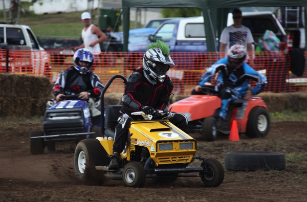 Racing lawnmowers battle on the track.