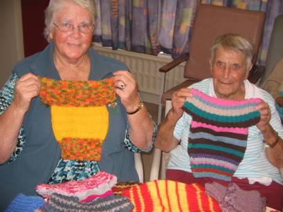 Heather Bentley & Norma Gedson with some of the brightly coloured fish-n-chip babies garments to be donated.