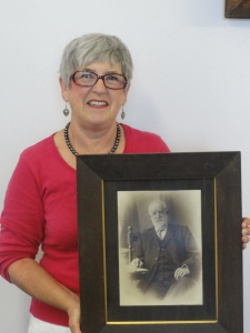 Jenny Jordan holding a potrait of her great-grandfather Frederick Beaven.