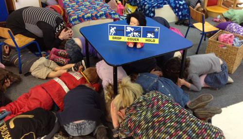 Well-drilled youngsters: Staff and children at Kelson Kindergarten go through a mock "drop, cover and hold" exercise.