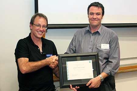 Associate Professor Brett Gartrell accepts the award from Jason Roxburgh of the Department of Conservation 