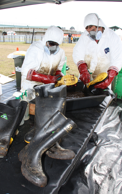 Tourists from Chile, Lorena Bravo and Sebastian Gabler pitch in at the wildlife centre to clean boots and other gear used in the oil clean up.