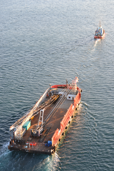 A tug tows container barge ST60 away from Mt Maunganui today to begin testing its capability and stability. Salvors plan to use it to take the remaining 1280 containers off the Rena