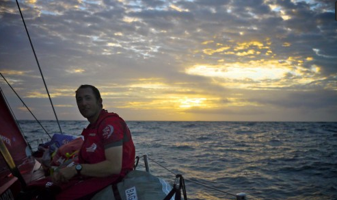 Andy McLean watches the sunrise on day 3 of leg 4 onboard CAMPER.