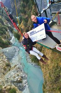 Susie Swaffield receives a cheque from Shotover Canyon Swing on behalf of the Help Heal Rhys Foundation.