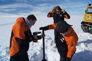 Adrian McDonald on left with a drill on the ice in Antarctica.