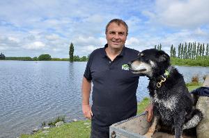 Chris Allen and working dog Ace by the irrigation lake that Chris created on his farm near Ashburton.
