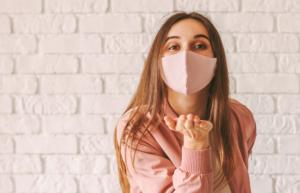 Women with face mask blowing a kiss