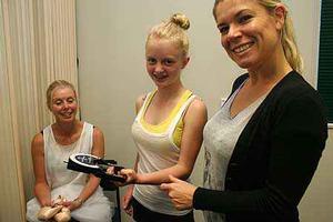 Wendy Jessup looks on as her daughter Eden tests her muscle strength, under the supervision  of Massey Nutrition researcher Sarah Mitchell.