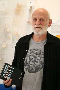 exhibition project coordinator Luit Bieringa, who is  holding a copy of a book about Arthur Riley the  founder of the Wellington School of Design.