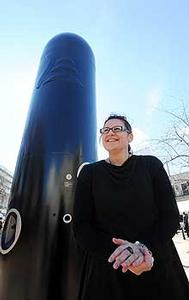 Maori visual artist Rachael Rakena stands next to  the black pou of Haka Peep Show in Dunedin. 