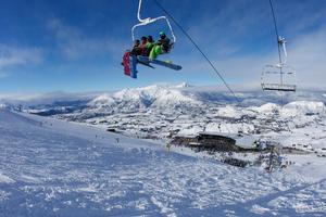 Riding the lift at Coronet Peak with The Remarkables in the background (photo by: Tony Harrington/NZSki)