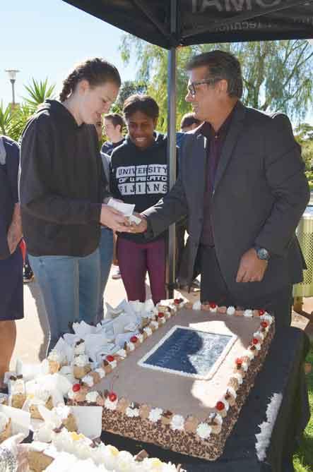 Students line up for cake, served by CE Dr Leon Fourie