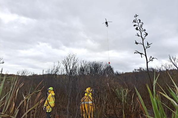 Helicopter supporting ground crews to extinguish hotspots at the Tiwai Road fire, Awarua, this morning.