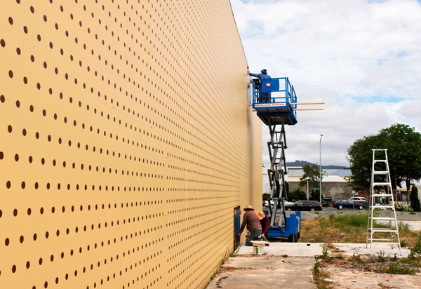 Thousands of black dots are being painted on a large wall in Sydenham to form the background of Wayne Youle's giant shadowboard.