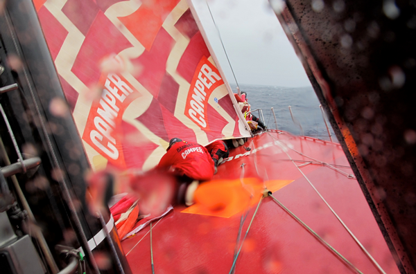 Stu Bannatyne secures a sail on CAMPER's bow during a sail change.