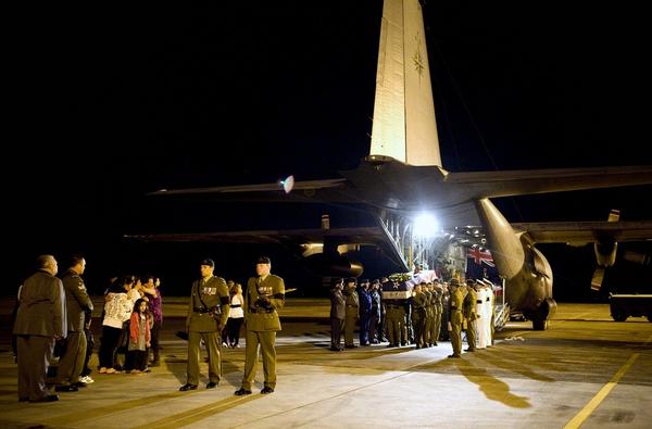 Senior military officials pay tribute to CPL Hughes as he is carried off a RNZAF C-130 aircraft.