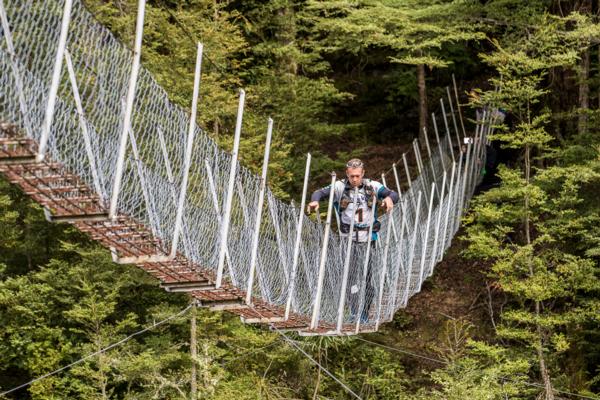 Chris Forne of Team Seagate crossing a swing bridge near Waikaia GODZone 2015