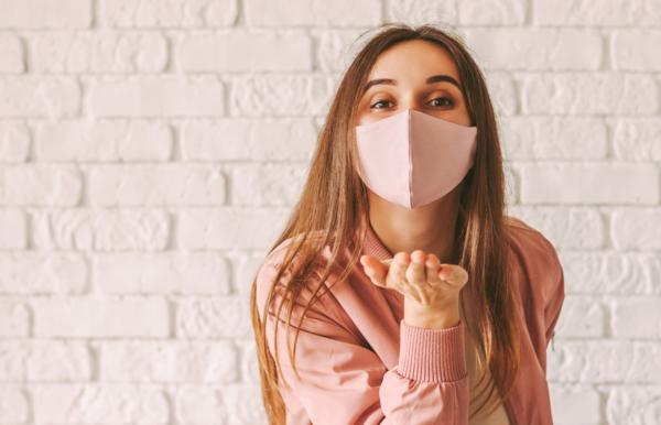 Women with face mask blowing a kiss