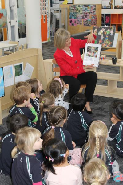 Executive Principal, Gillian Simpson, reads a picture storybook about the Pre-school to the current pupils at the celebration