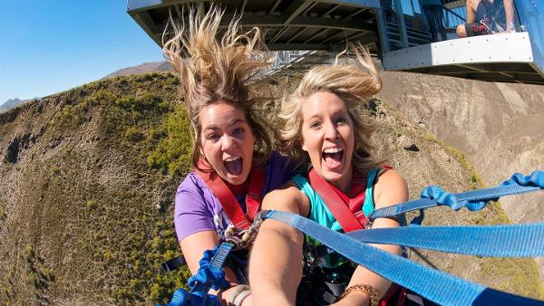 Two thrill-seekers scream on a bungy swing