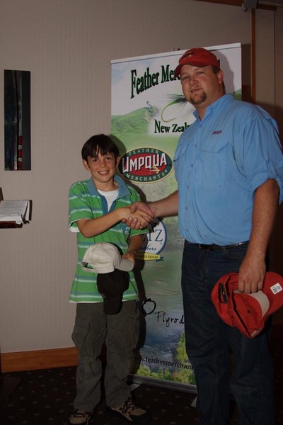 10-year old Jacob Bond receives congratulations and a cap for his excellent fly-tying