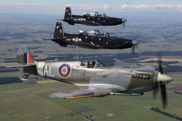 Supermarine Spitfire and two modern Beechcraft T-6C Texan II aircraft flying in formation