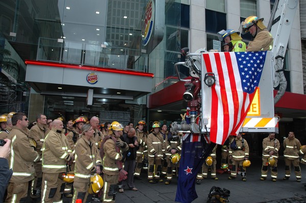 New Zealand firefighters pause and listen to names being read of all NZ firefighters who have died in the line of duty before their 30 floor climb.