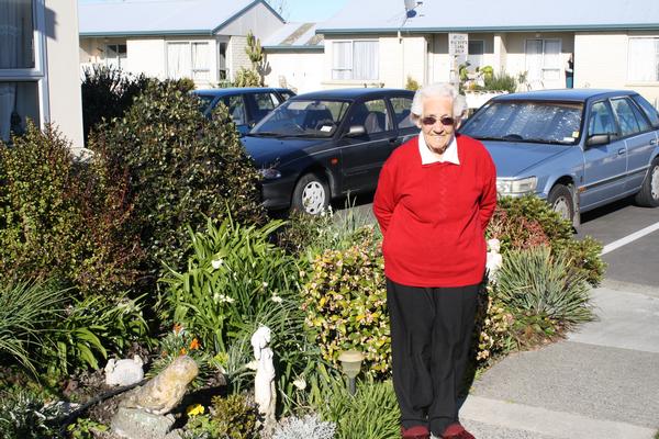 Topsy Olsen stands alongside her lovely garden