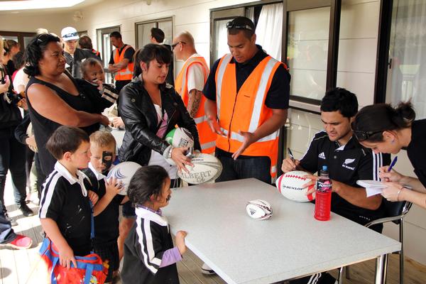 Piri Weepu signs an All Blacks supporter's rugby ball.  People queued for about an hour to get items autographed