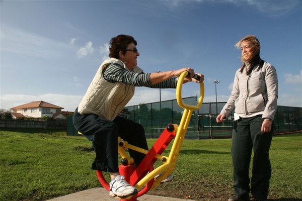 Manukau Parks Ranger Kristen Ross guides Robyn Fox, a local resident, in the use of elliptical cross trainer