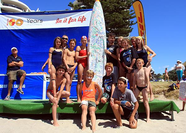 Matt Sutton and Christchurch members with the board his company Sonic Surf Crafts donated.