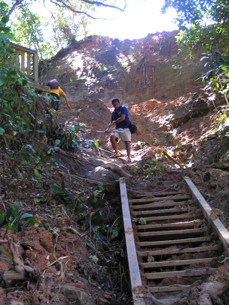 Tourists navigate the final descent into Cathedral Cove where a slip has washed out the track and stairs