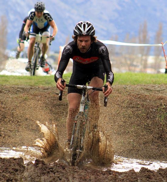 Alex Revell enjoys the mud pit in today's National Championship race in Wanaka.