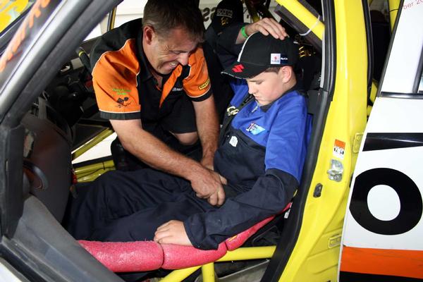 16-year-old Oncology patient Wayne Cherry gets secured in to the Suzuki Swift Sport Cup car of Christchurch's Hamish Cross for the ride of his life around the Manfeild race circuit recently.