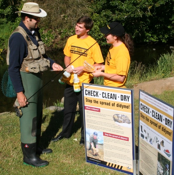 Taranaki didymo education team Josh Southee and Jane Bowden discuss cleaning techniques with angler Bart Jansma.