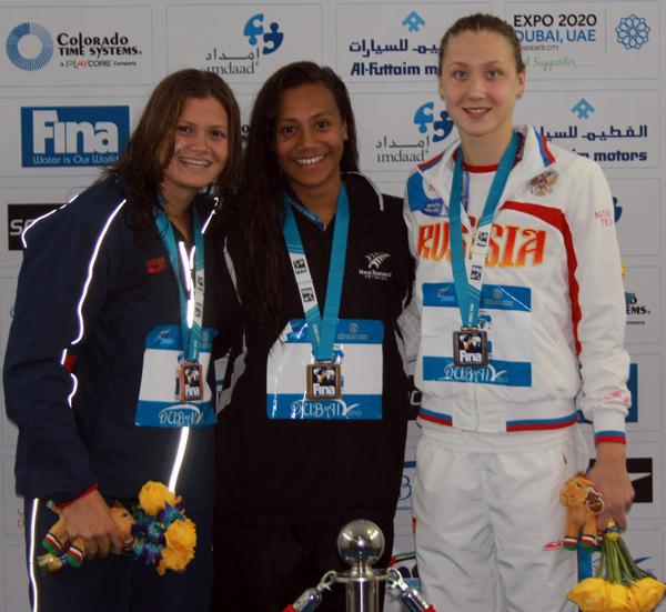 Gabrielle Fa'amausili (centre) on the podium after winning the 50m backstroke title at the FINA World Junior Championship in Dubai.