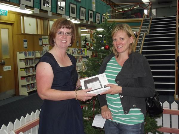 Adele Simmonds accepts her new Kobo eReader from Hastings District Libraries Manager Paula Murdoch