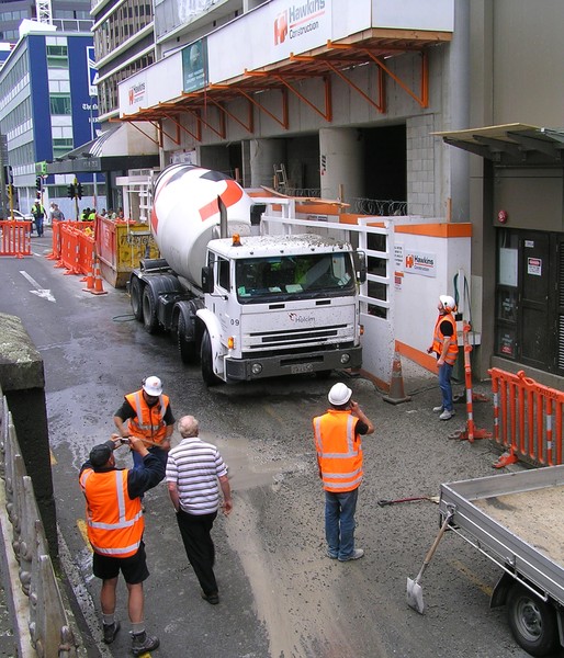 Workers assess the mess and the damage to a Holcim Concrete mixer