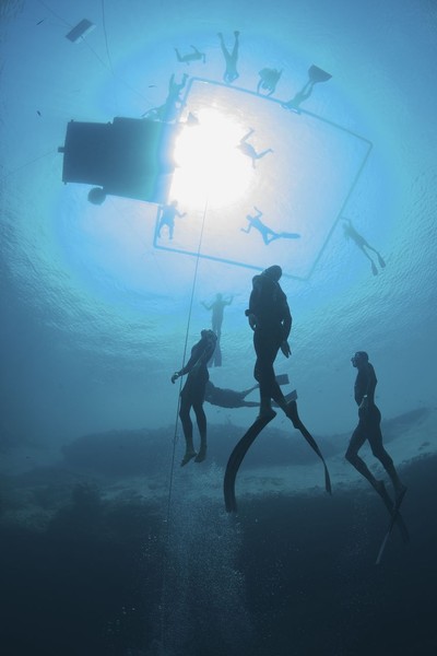 Will Trubridge (NZL) is surrounded by safety divers as he ascends to complete a new world record in the constant weight, no fins (CNF) discipline at the Vertical Blue freediving competition on April 26, 2010.