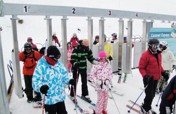 Skiers and boarders at Coronet Express chair RF gates - Coronet Peak