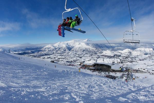 Riding the lift at Coronet Peak with The Remarkables in the background (photo by: Tony Harrington/NZSki)