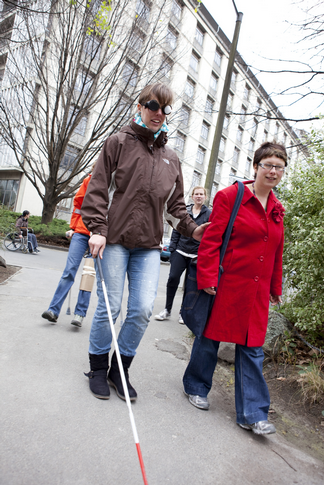 RNZFB mobility instructor Miriam Stettner (right) guides UC student Judith Aussendorf around campus using a long cane.   