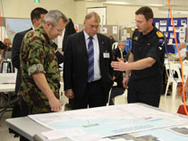 Dr Wayne Mapp, Minister of Defence, talks to Defence Force personnel involved with the recovery and cleanup from the stricken ship Rena. They are pictured in the Incident Control Centre in Tauranga.