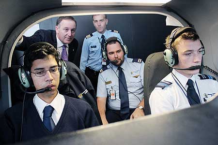 Prime Minister John Key with aviation students and instructors checking out a flight  simulator at the School of Aviation.
